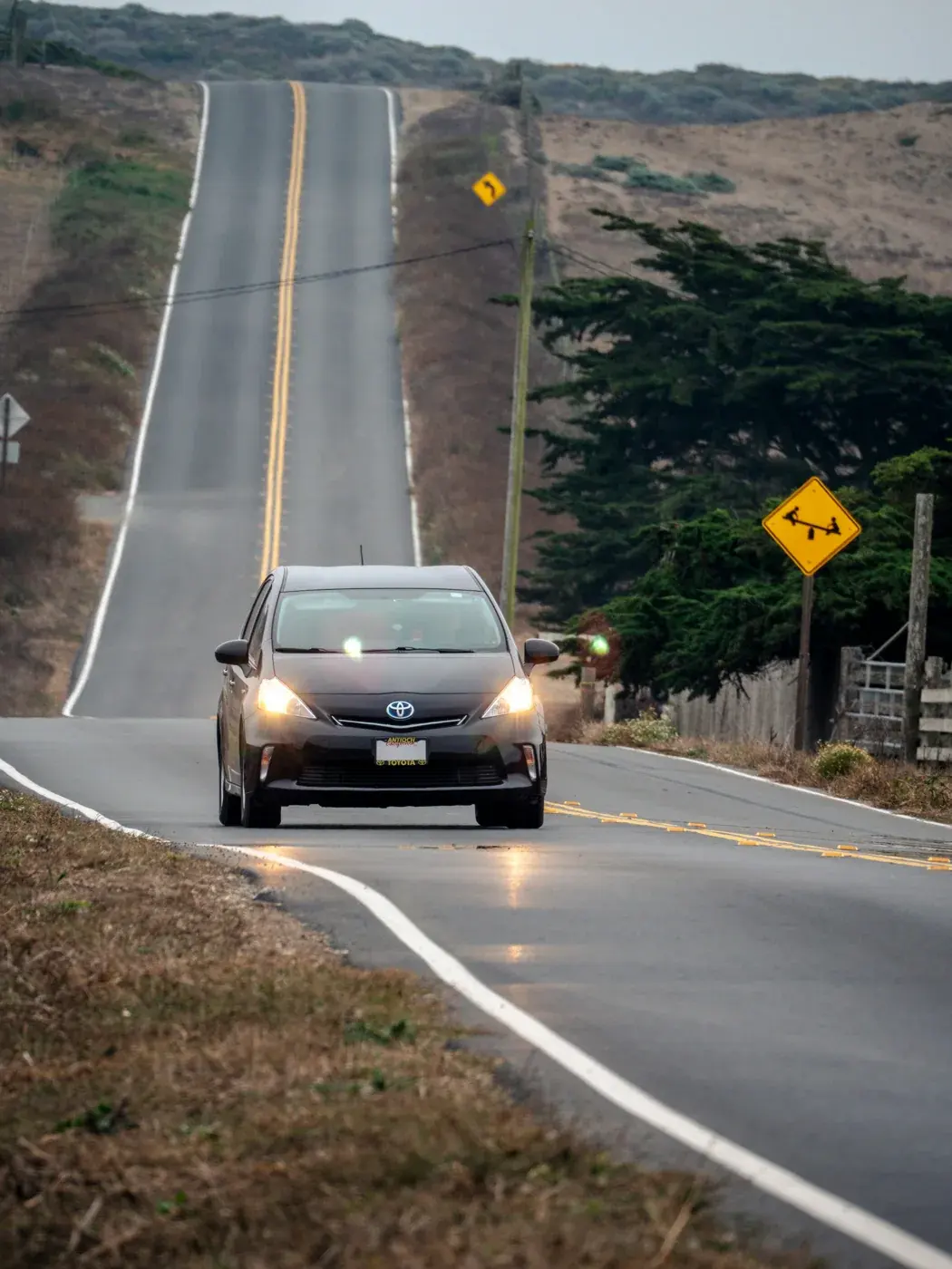 起伏のある道路を走る車の例。長い下り坂では、その車で指定された方法でエンジンブレーキも使います。撮影場所の勾配や車のギヤ位置を示す写真ではありません。