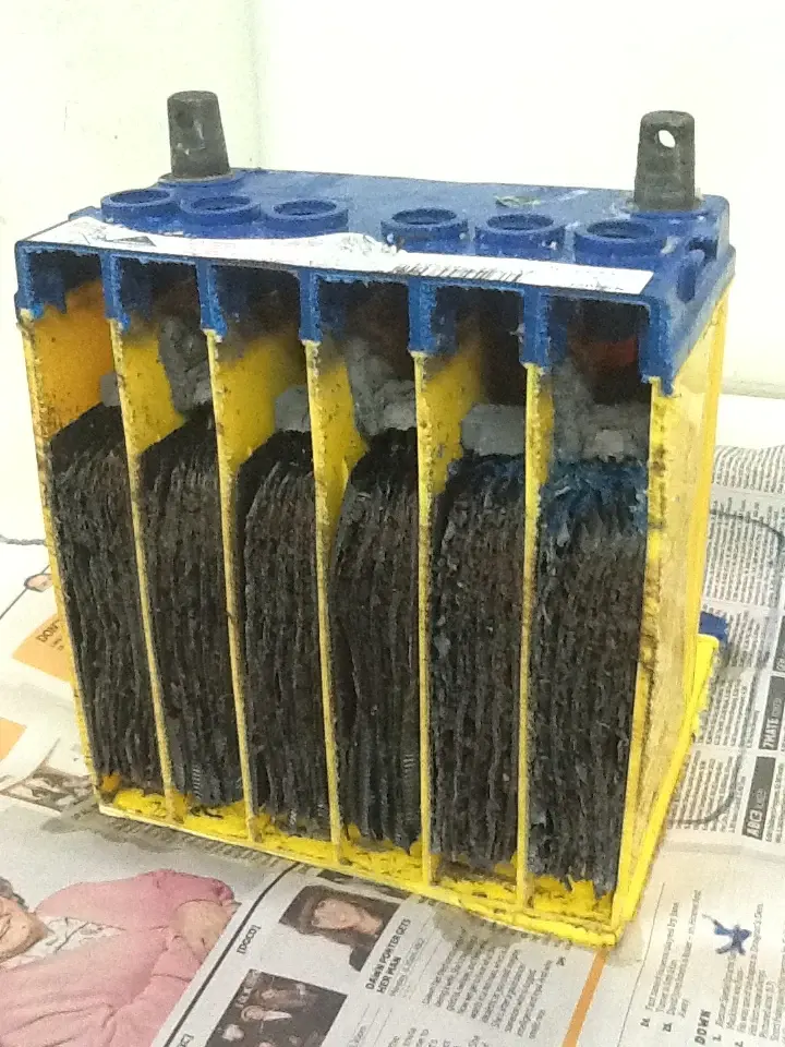 ケースの内部に仕切りと極板群を持つ実物展示。充電中の化学反応を写した写真ではなく、極板の材料や極性は写真の色から判断しません。