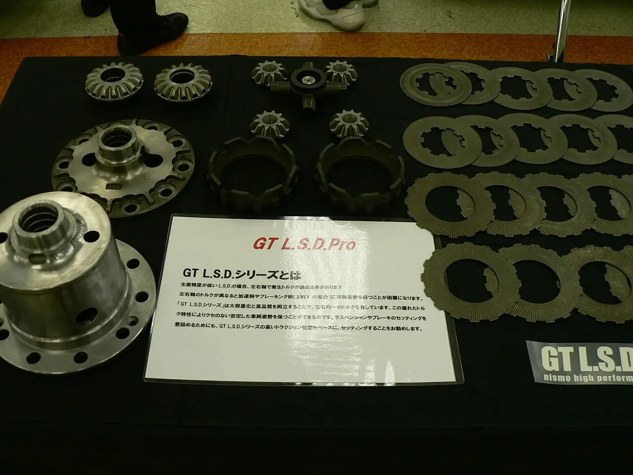 NISMO GT L.S.D. Proの構成部品。右側に重ねて使う摩擦板、中央にプレッシャーリングや歯車などが並ぶ実物展示。写真だけで1.5WAY・2WAYの設定は断定しない。