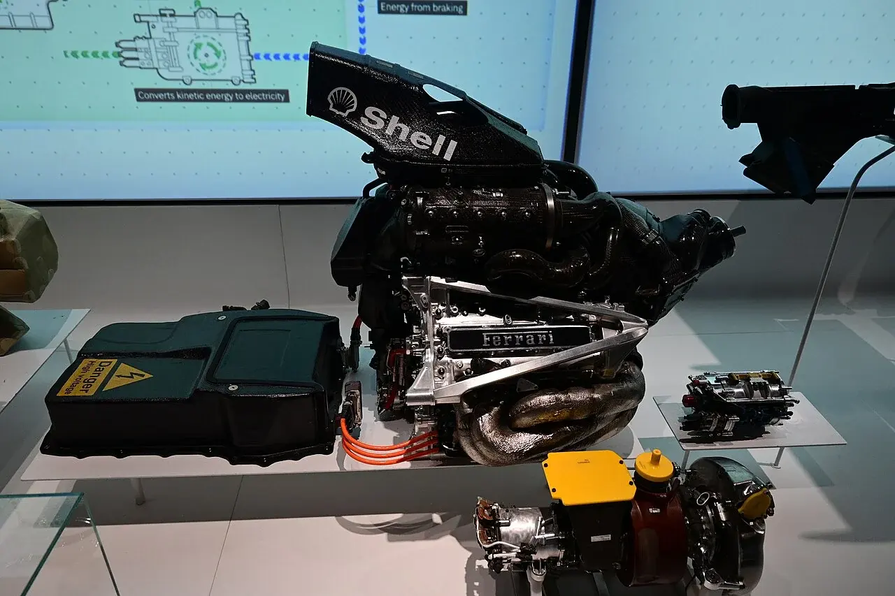 Ferrari Tipo 065/6のエンジンと、Mercedes-AMG W10のMGU-Kなどを並べた展示。別メーカー・別仕様の部品で、一台のPUの接続を示す写真として使っていません。