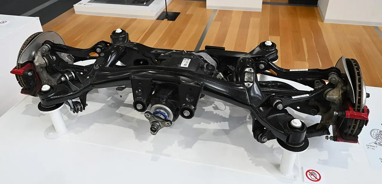 Toyota Supra A90の後輪マルチリンクの展示。左右の車輪支持部へ複数のリンクがつながり、中央には差動装置が収まっています。
