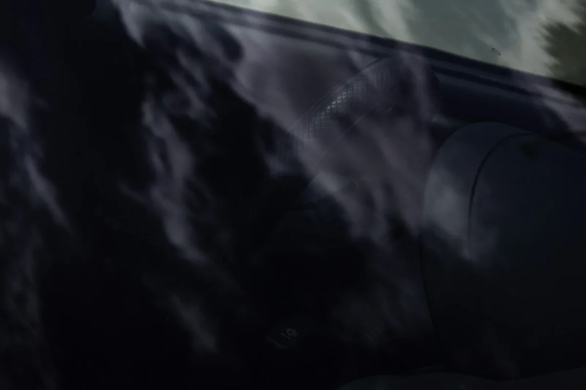 車のガラス表面と映り込みの写真。内側の熱線を掃除するときは、ガラスの汚れだけでなく細い線の傷付きにも注意します。