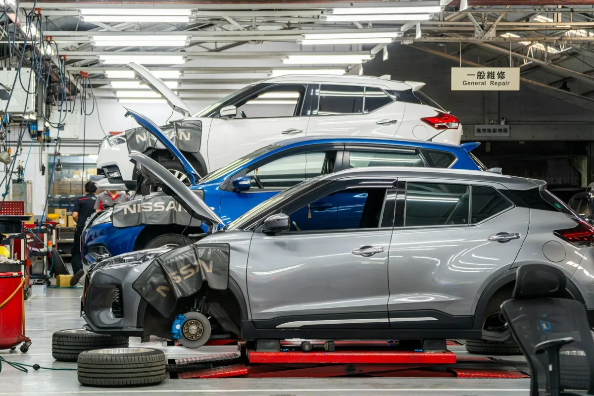 車をリフトに上げて整備する工場の例。普段の制動でも振動する場合は、起きた場面を伝えて点検を相談します。
